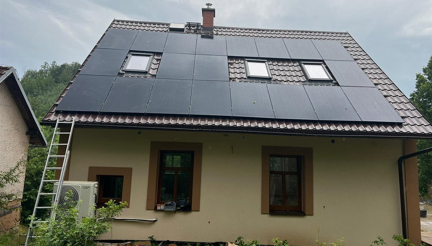 Dům s černými panely na hnědé taškové střeše se třemi střešními okny